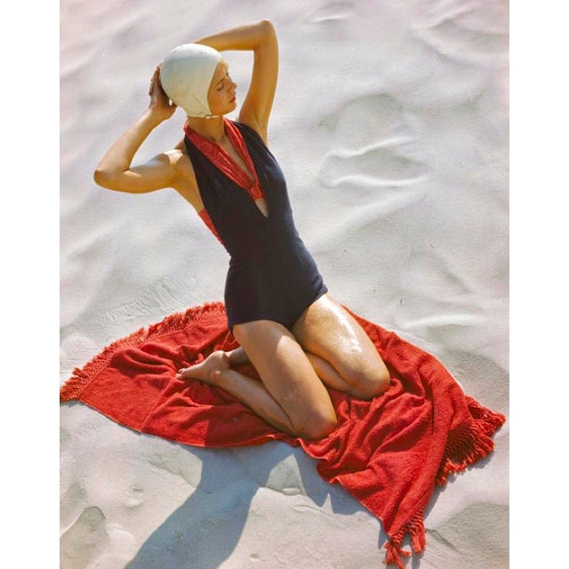 Girl On A Red Beach Towel by Toni Frissell Beachwear fashion shoot, 1947 featuring a girl on a red beach towel in a dark...