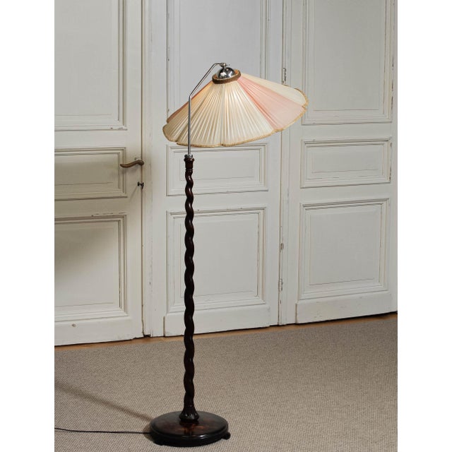 Elegant 1940s floor lamp featuring a beautifully hand-carved twisted wooden stem and a large original pleated fabric shade...