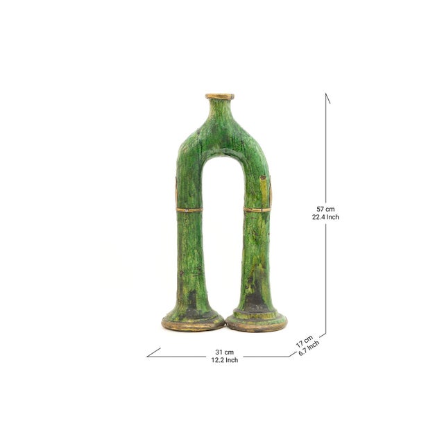 An arched silhouette rises from twin bases in rich Tamegroute green, its glossy glaze catching light like water over...