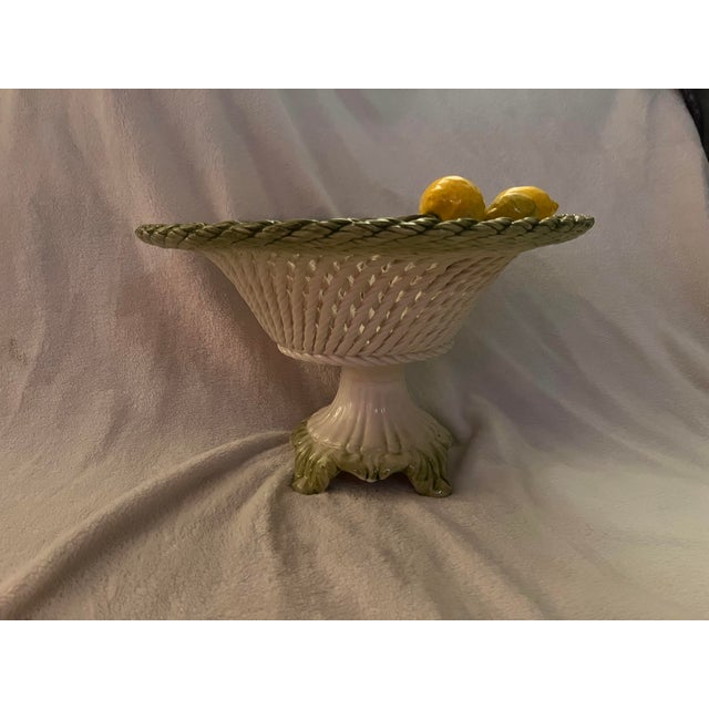 Darling lemon braided basket with pedestal handmade in Italy by Lanzarin Ceramiche. The basket is slightly titling to be...