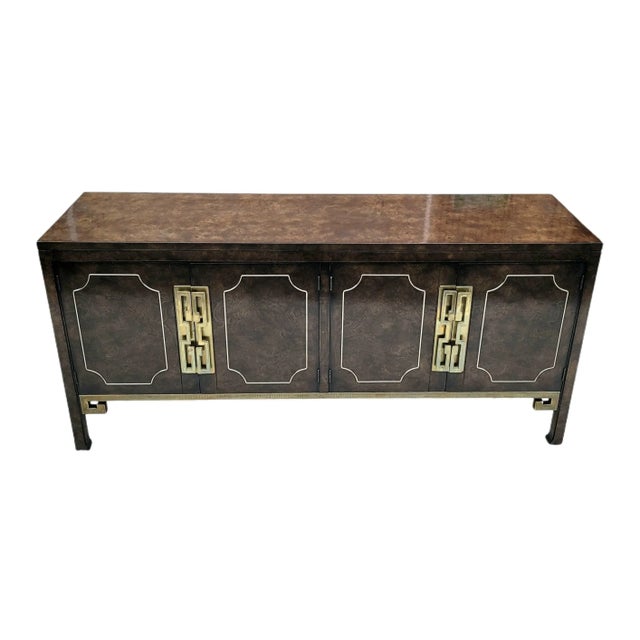Featured is a grand Hollywood Regency Amboyna Burl Wood and Brass Credenza by William Doezema for Mastercraft; with 4...