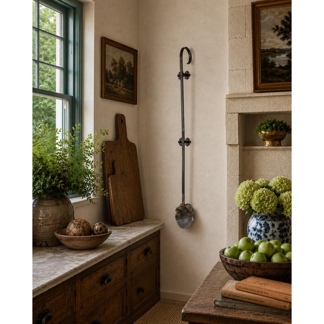 An unusually large early 20th-century commercial ladle, hand forged from iron and retaining a richly weathered surface...
