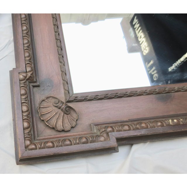Edwardian wall mirror in wood. Wide panel frames with outer and inner egg and dart trims. Scalloped details on the corner...