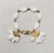 This is part of Chairish’s Costume Jewelry assortment. 1950s goldtone and white beaded with two "fans" charm bracelet with...