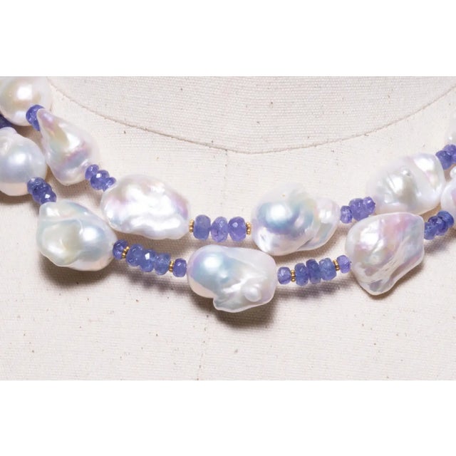 A double strand of large, white, baroque pearls with faceted tanzanite beads and 18K gold spacers. Blush baroque pearls...