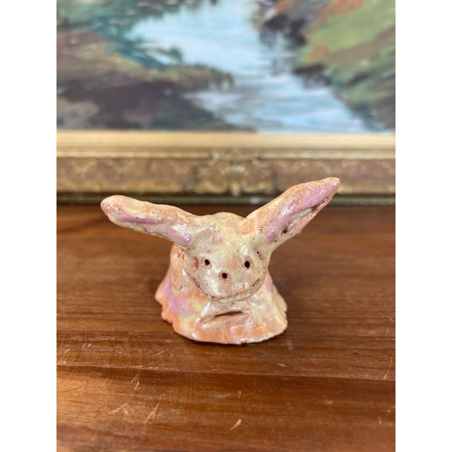 This imaginative hand-built ceramic sculpture depicts a fantastical creature with oversized, upright ears and a wide,...