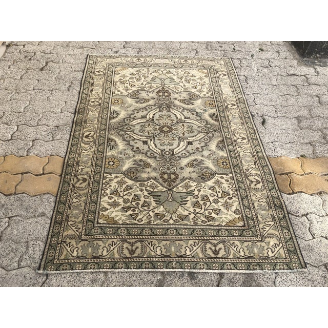 This is a vintage Turkish Oushak rug from the 1960s. The piece was hand-knotted.