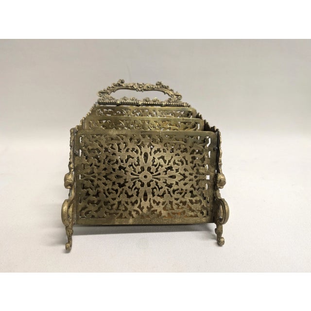 An intricately crafted antique brass letter holder that features three letter slots, curved feet, ornate carving and two...
