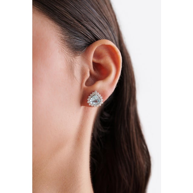 These Halo Stud Earrings, Featuring 3.55 carats of natural trillion-cut aquamarines, set in 18k white gold. Each...