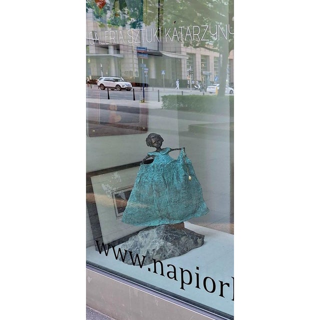 This captivating sculpture presents a whimsical figure, intricately designed with a disproportionately large dress. The...