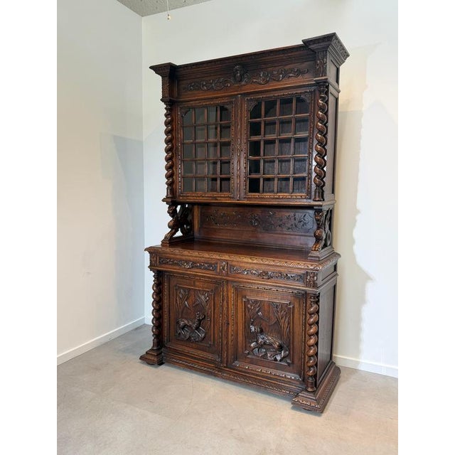 An impressive antique carved oak display cabinet showcasing exceptional craftsmanship and timeless elegance. Featuring...