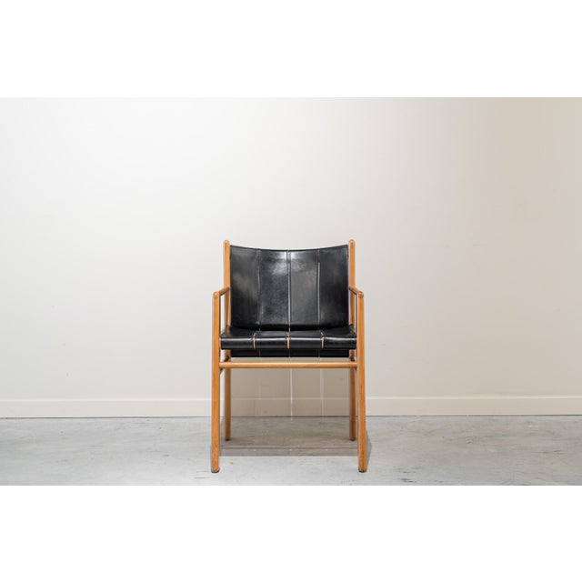 Armchair made of light alder wood and black leather straps by Gianfranco Frattini for Bernini in the 1980s. The clean...