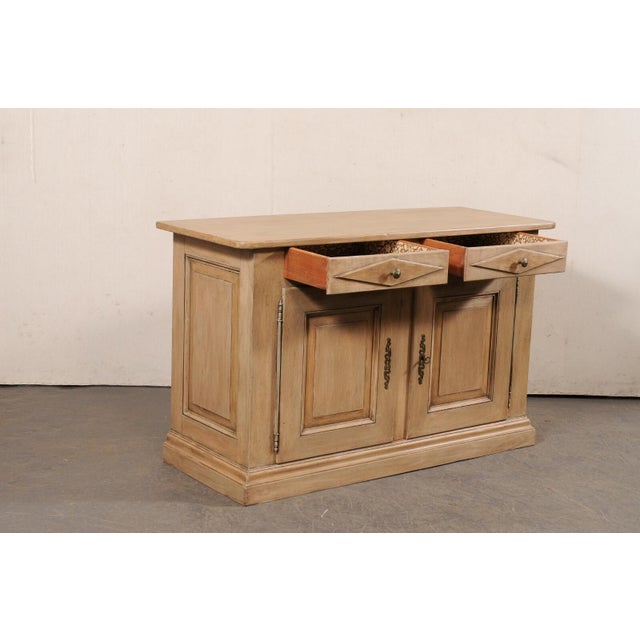 An Italian wooden buffet cabinet from the mid 20th century. This mid-century cabinet from Italy features a rectangular-...