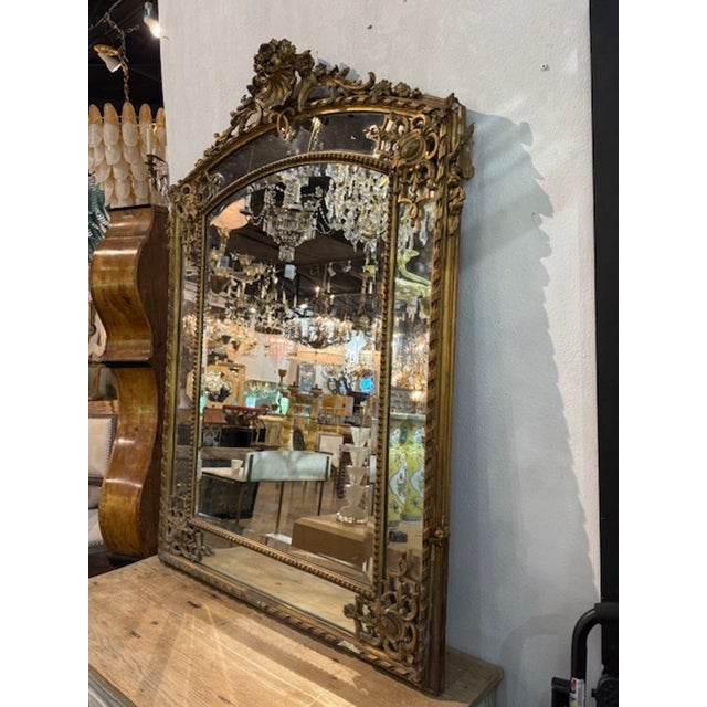 19th century French Regence carved and gilt-wood mirror. A French Régence carved and giltwood mirror is a...