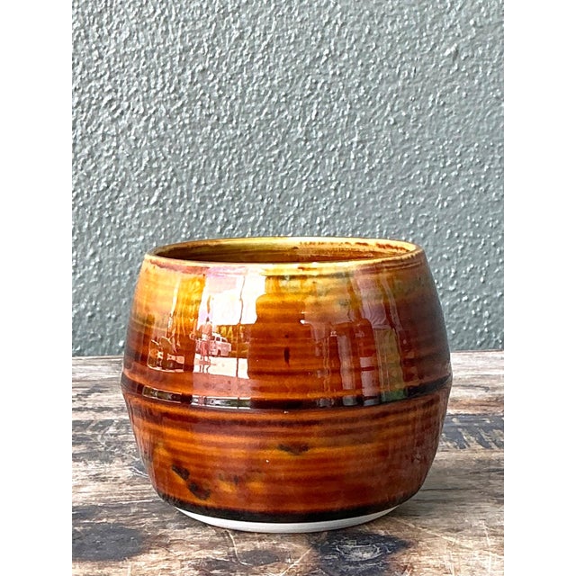 This vintage handcrafted studio pottery bowl is a compelling example of mid-century ceramic artistry, distinguished by its...