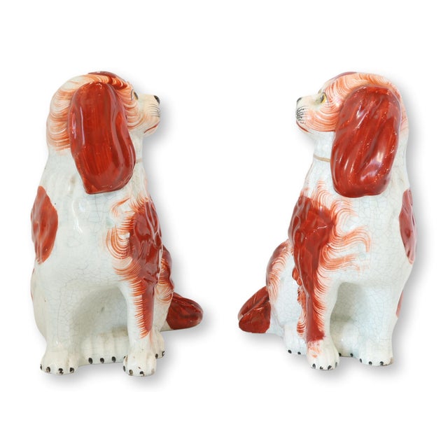 Pair of antique Staffordshire spaniels, circa 1860, hand-painted in russet and white. Rare separate front leg modeling....
