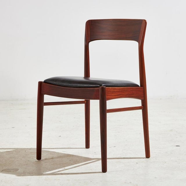 Completely restored ‘Model 26’ rosewood dining chair with fresh black leather upholstery. Designed by Henning Kjærnulf for...