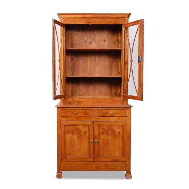Display cabinet, France, circa 1835, cherry wood; upper section removable, two-door with curved glass panes; lower section...