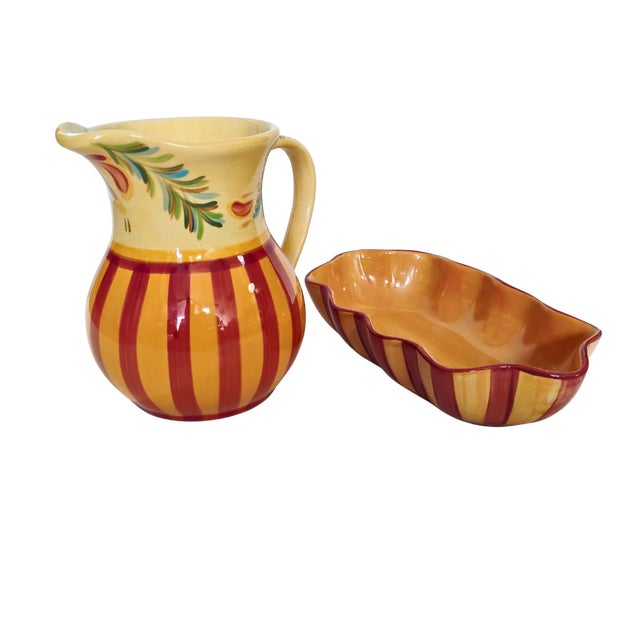 This vibrant hand-painted ceramic set features a classic pitcher (8"x8") and a matching wavy-edged dish (11"x6") adorned...