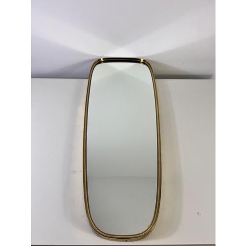 This elegant Italian wall mirror from the 1960s showcases the refined craftsmanship and modernist sensibility...