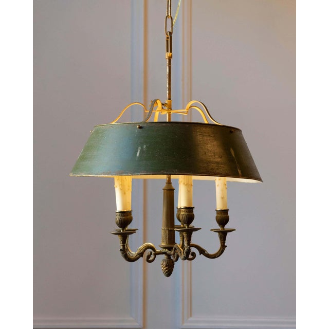 A refined 19th-century French bouillotte chandelier, crafted in bronze with its original green tole shade. Classic in form...