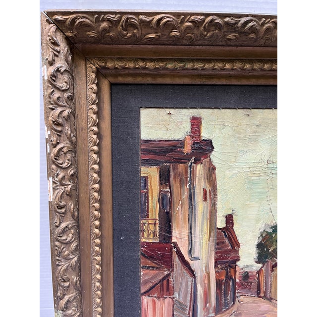 An original oil on canvas painting featuring a European landscape street scene with buildings and foliage. Finished with a...