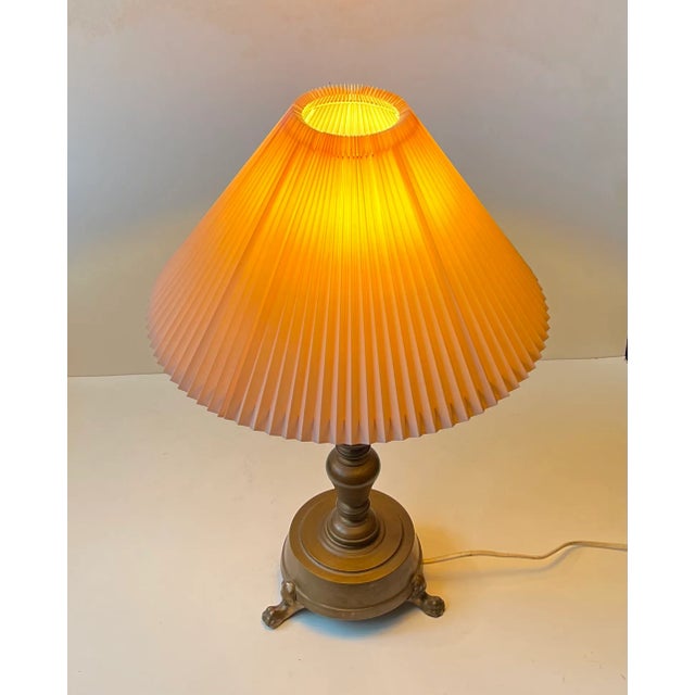 A stylish column table lamp with lion paws - feet executed in patinated bronze and featuring a fluted vintage pink shade....