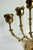 Dating to the mid-20th century, this sculptural brass menorah features rosebud-form candle cups supported by stylized...