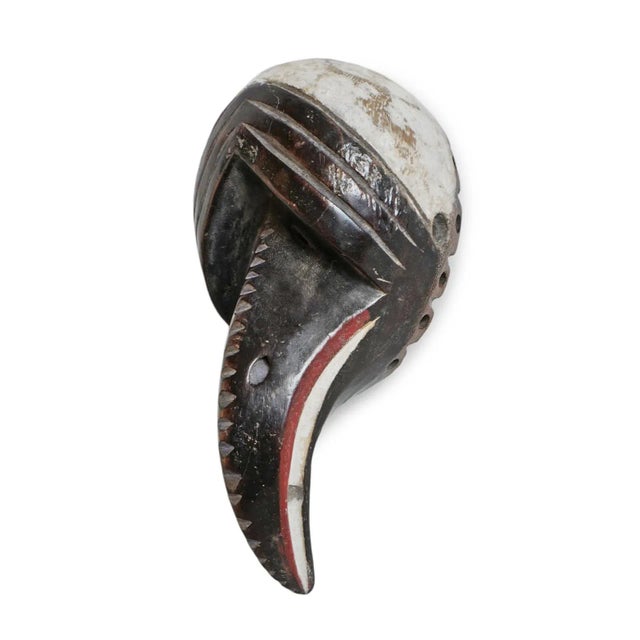 Vintage bird mask from Western Africa. Original black and white finish with red accents. Characteristic signs of age and use.