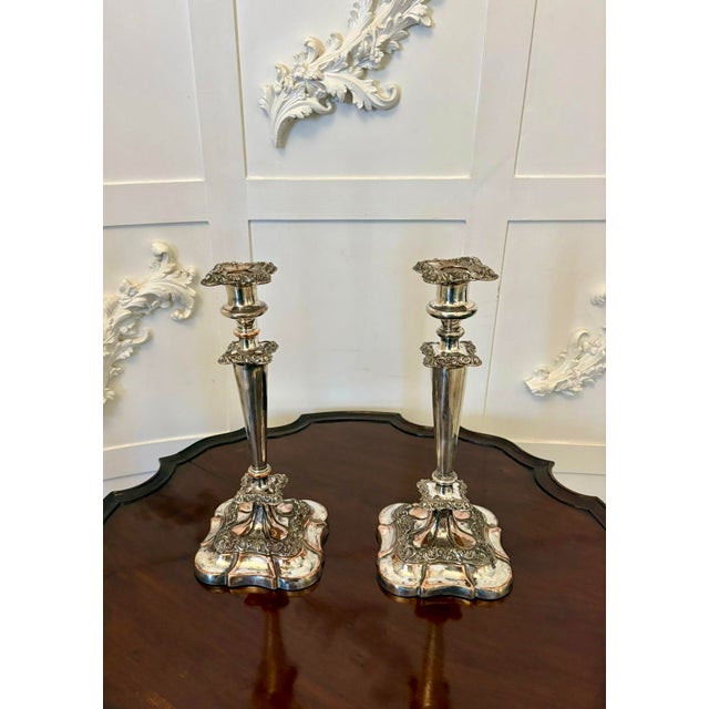 A fine pair of tall antique silver-plated candlesticks, elegantly proportioned and standing on substantial shaped bases....