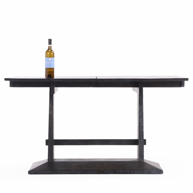 A substantial French dark cerused oak table or desk, C. 1940, featuring a bold, architectural form and richly textured...