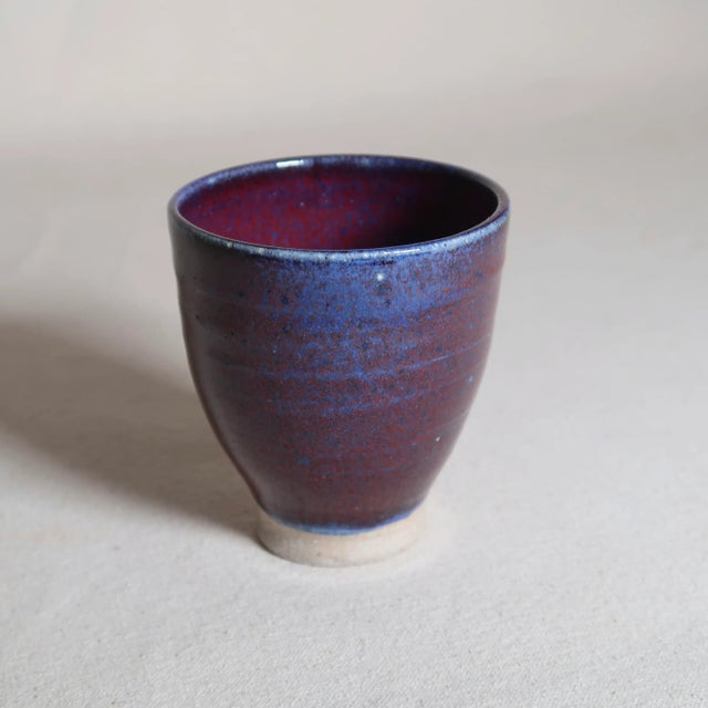 This original studio pottery cup or small vessel features a refined, hand-thrown form with a subtly tapering silhouette...