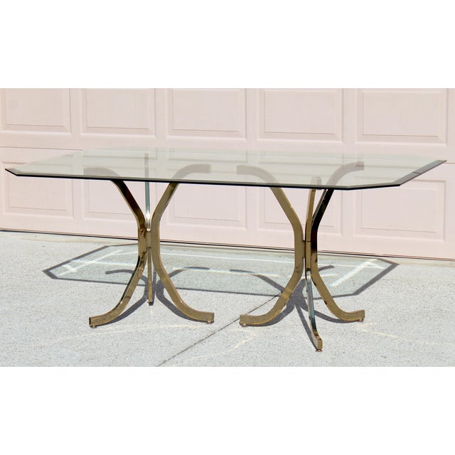A rare and exquisite find, this vintage brass and glass dining table embodies the timeless sophistication of mid-century...