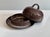 A round, handmade butter dish from the Serocka workshop, crafted in a brown, beige-streaked earthenware glaze on a dark...