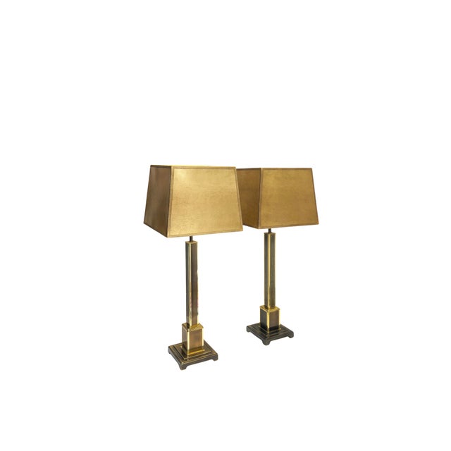 A pair of exceptionally elegant tall table lamps with a distinctly architectural design. Slender square columns are framed...