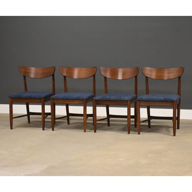 A set of four mid century modern walnut Dania dining chairs with new blue tweed fabric and restored walnut frames by...
