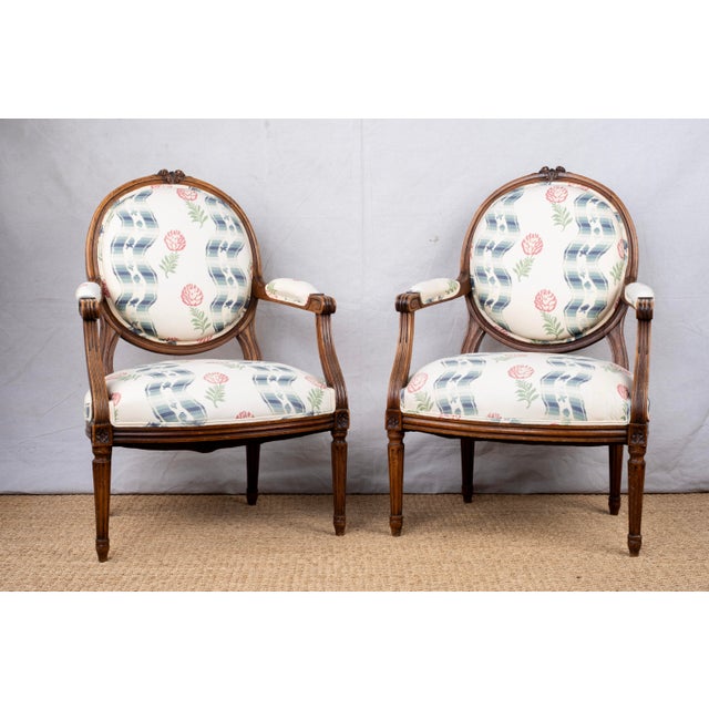 A pair of antique armchairs, late 19th century, French. Louis XVI style and featuring original carved wood frames with a...