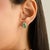 Striking silver stud earrings featuring marquise-cut emeralds totaling approximately 1.80 carats, framed by a delicate...
