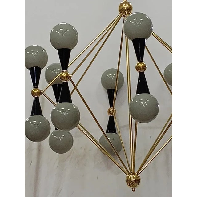 Particular circular sputnik, with brass structure and Murano grey glass spheres. It looks like a system of planets that...