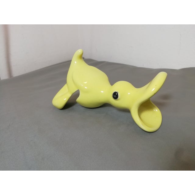 A beautiful object with a very fun and playful use. A parro-shaped baby food eater that fits on the edge of the plate. One...