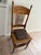 This is a classic turn-of-the-century Americana style pressed-back spindle chair, featuring an ornate faux-carved crest...