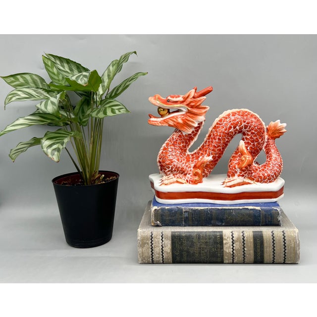 Striking, mid to late 20th century hand-painted Chinese porcelain dragon sculpture featuring a vibrant iron-red glaze with...
