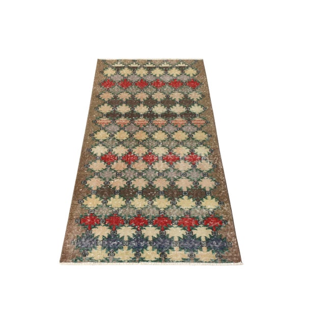 Hand-knotted in wool originating from Turkey circa 1960-1970, this vintage mid-century 3x6 runner belongs to Rug & Kilim’s...