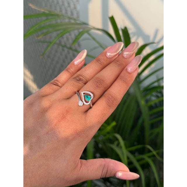 This elegant pear cut emerald and diamond Toi et Moi bypass ring is crafted in 14K white gold. The emerald measures...