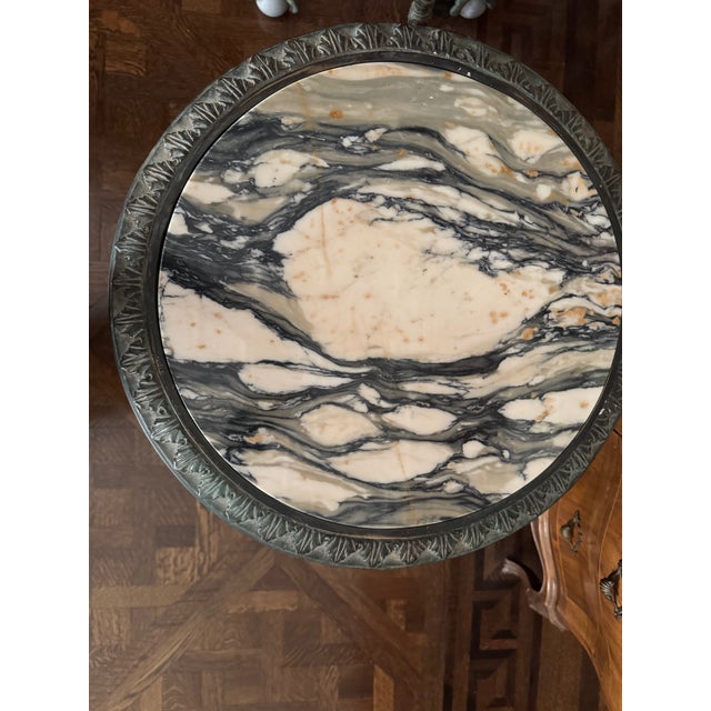 An exceptional pair of neoclassical-style gueridon side tables, each featuring a striking marble top with dramatic veining...