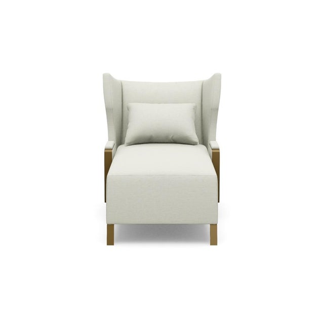 Its shapely silhouette features a high, winged tight back and generously extended seat, offering an inviting retreat for...
