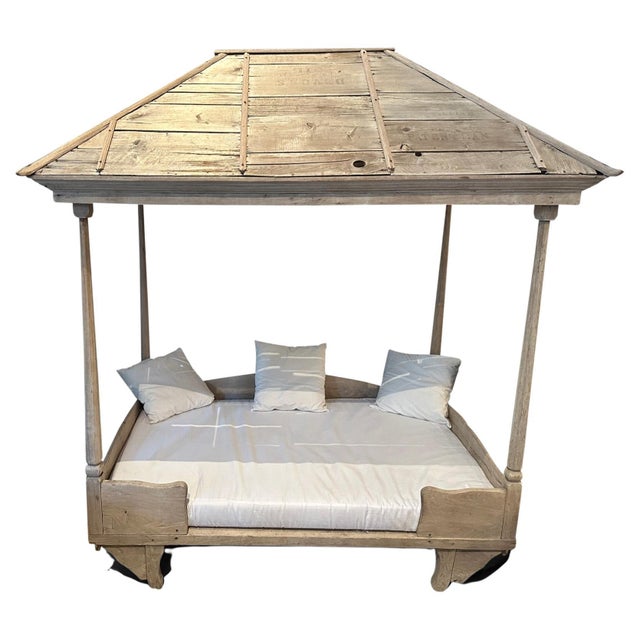 This beautiful antique daybed with its iconically shaped slatted teak canopy is a unique piece from Sumatra. The teak wood...