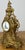 A stunning Vintage brass clock featuring an exceptionally ornate Rococo-inspired design with elaborate scrollwork,...