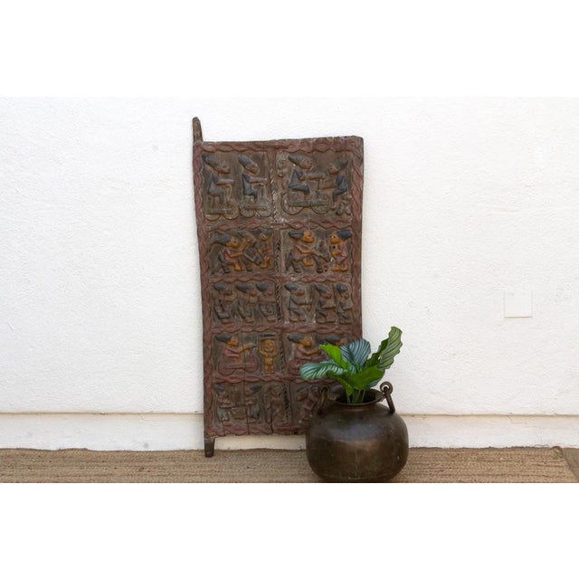 This is a door that gets people talking the moment they notice it: two of its carved figures are riding bicycles, mid-...