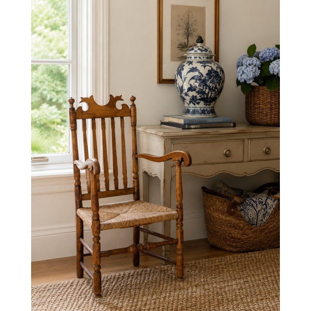 A beautifully preserved early 19th century New England armchair, handcrafted in maple and ash with a woven rush seat and...
